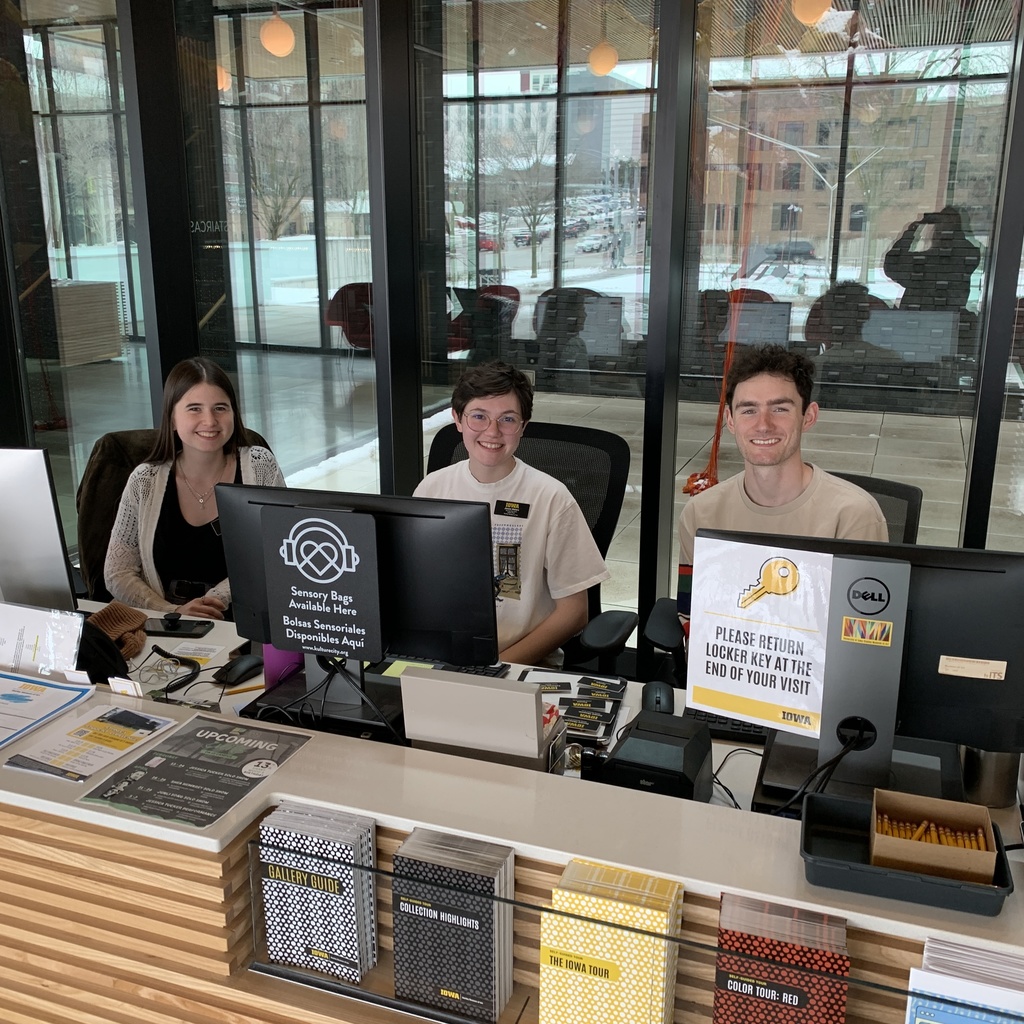 A photo of three gallery hosts seated at the Stanley Museum of Art front desk.