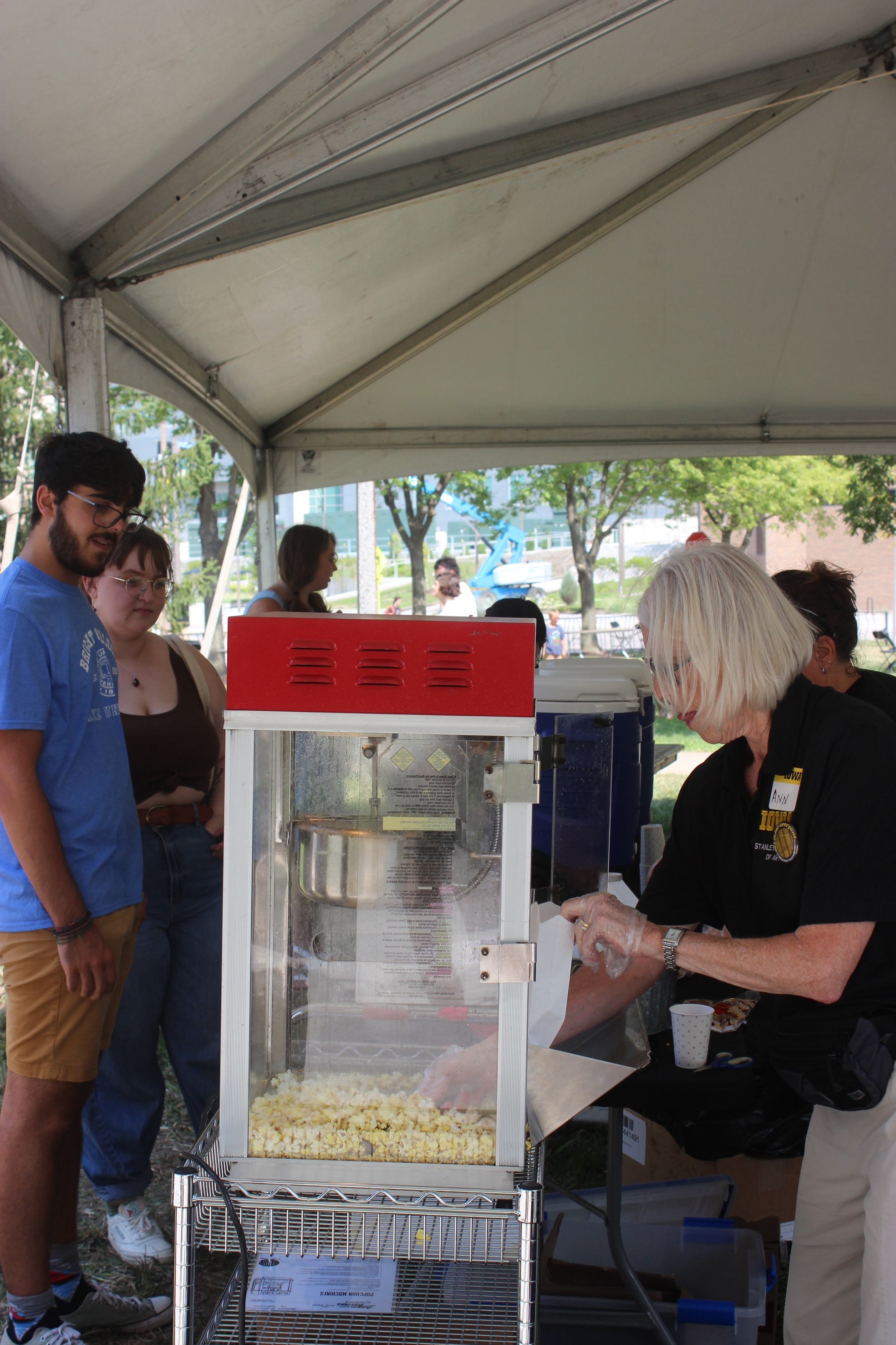 popcorn machine with people standing in line to grab a bag of popcorn