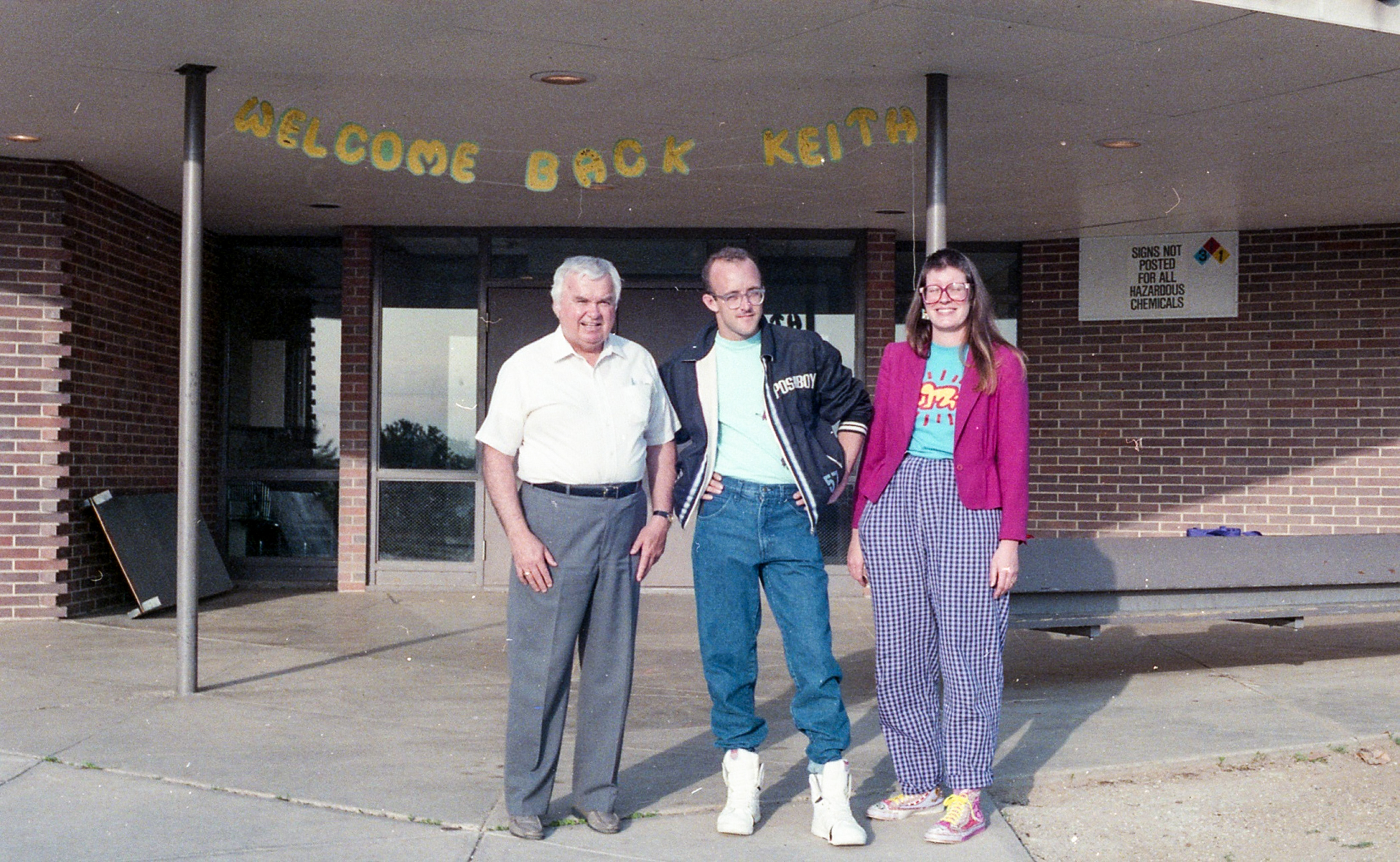 Paul E. Davis, principal of Ernest Horn Elementary School, Keith Haring, and art teacher Colleen Ernst pose in front of the school