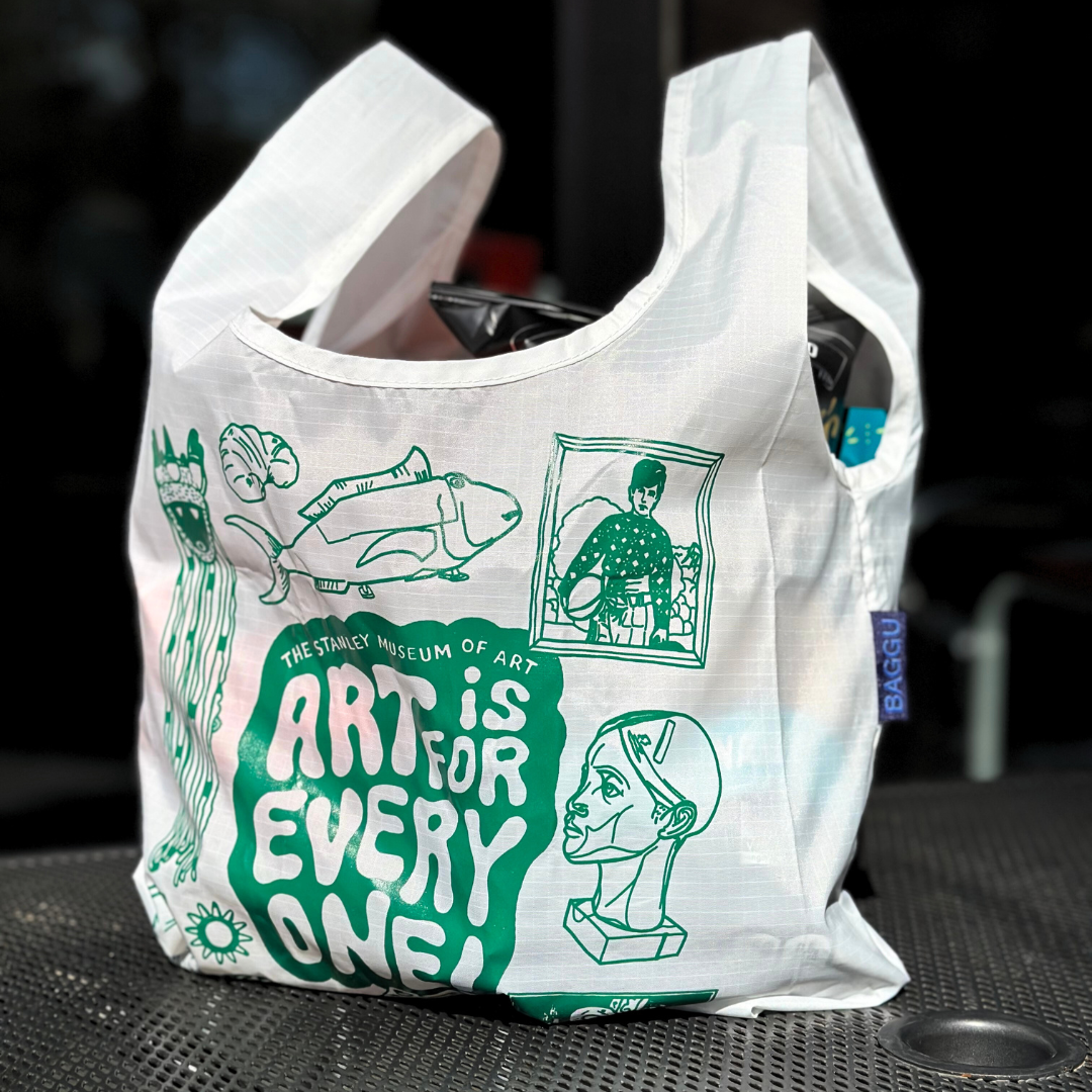 A photo featuring the Stanley Student Challenge Baggu bag prize. A white bag with green design on it, featuring the slogan "art is for everyone" and drawings of various works of art from the Stanley Museum of Art. 