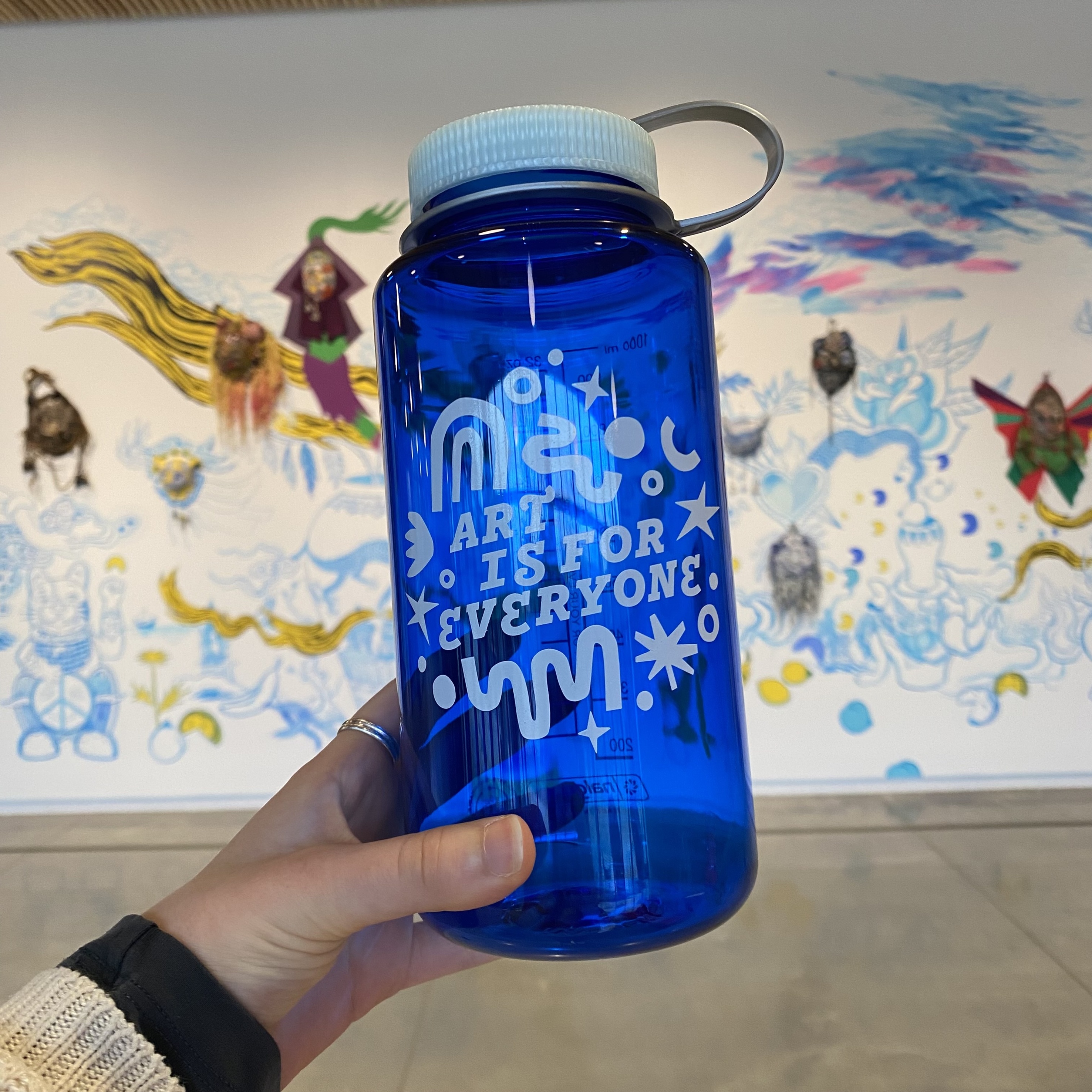 The Stanley Student Challenge water bottle is blue, with white vinyl lettering that reads "Art is for everyone"