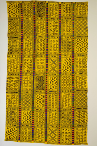 Large piece of bright yellow cotton cloth which features columns containing a variety of repeating symbols in black called adinkra that each hold their own distinct historic and philosophical meanings for the Asante people.
