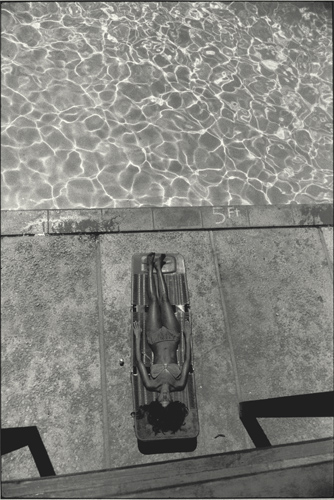 woman lying on a lounge chair seen from above on the deck of a swimming pool
