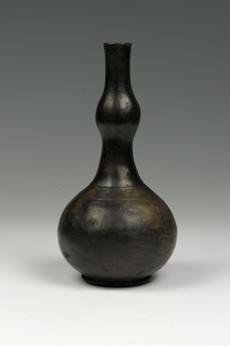 Shiny black pot with two round, bulbous section, the bottom of which is larger, separated by a narrow cylinder and with a narrow cylinder at the top.