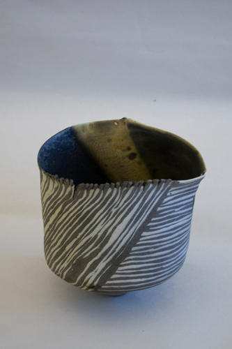 Small cylindrical cup painted with a black and white pattern resembling zebra stripes.