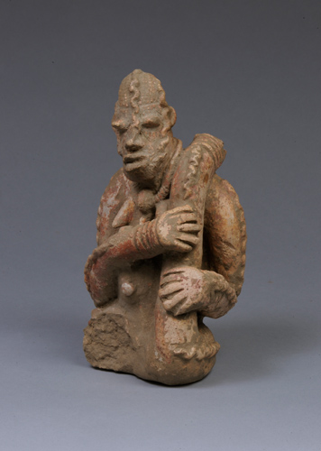 Seated figure with snakes wrapped around shoulders, head, and arms.