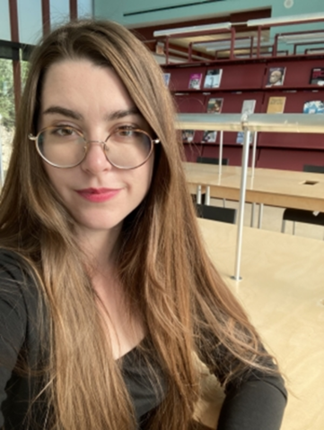 A photo of Abbey, with library shelves behind her.