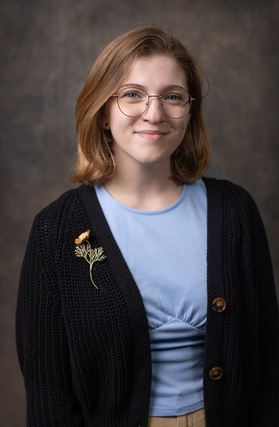 A photo of Katharine with a grey background. 