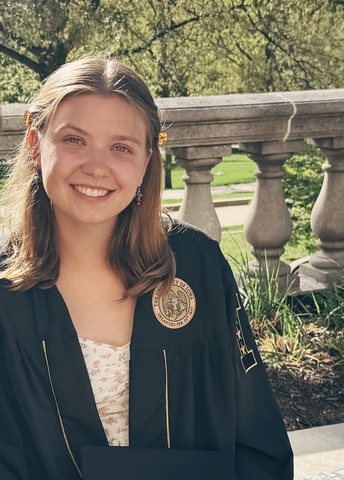 Annabel Hendrickson poses in her graduation robes on the Pentacrest.