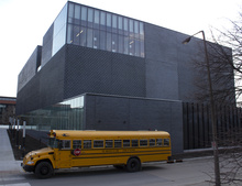 A yellow school bus parked outside the museum of art