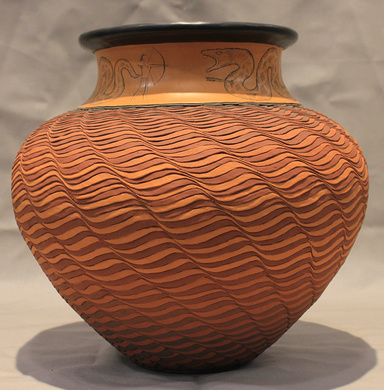 Red, earthenware post with wavy diagonal lines across the surface