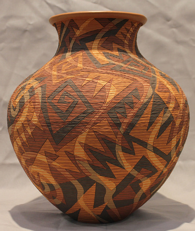 Red, earthenware pot with  black and dark orange geometric designs across the surface