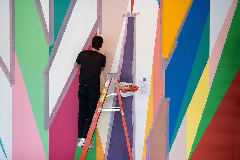 Alan Prazniak scales a ladder to paint during the installation of "Surrounding."