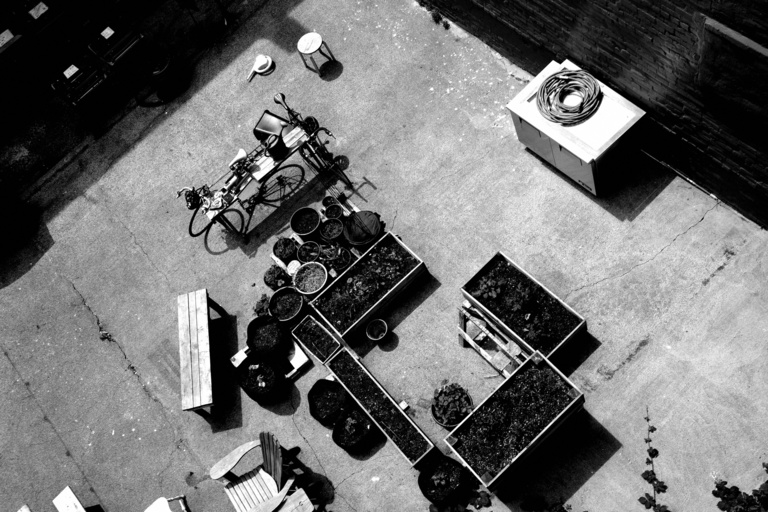 Graham's art: a black and white aerial photo of a courtyard with bikes and plant beds.