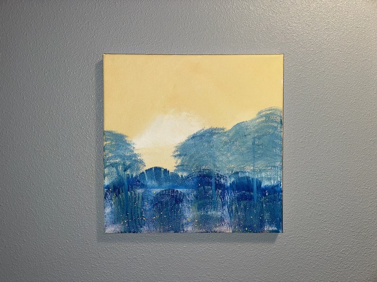 A photo of Jenna Mosnik's art: a landscape piece, with blues and yellows.
