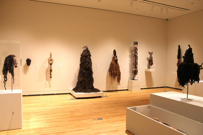 An installation view of "About Face," featuring a wide assortment of African masks.