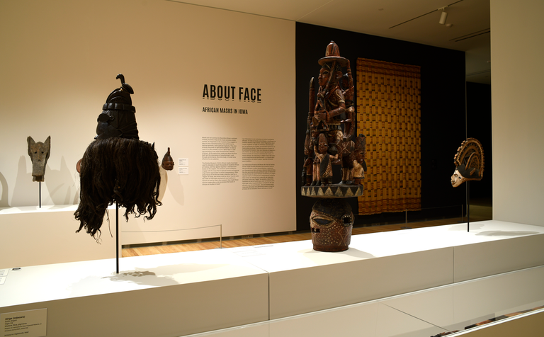 An installation shot of "About Face," featuring a few African masks.