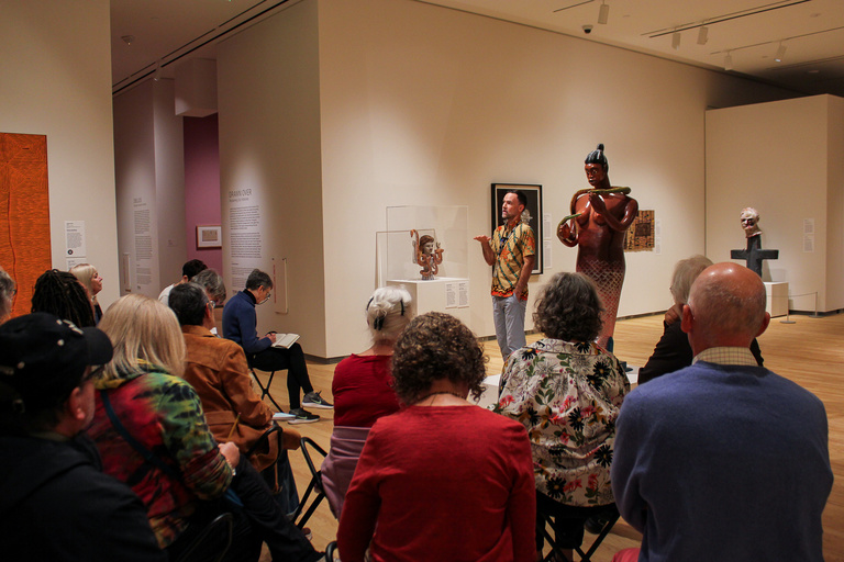 Curator Cory Gundlach speaking in gallery to audience about Mami Wata