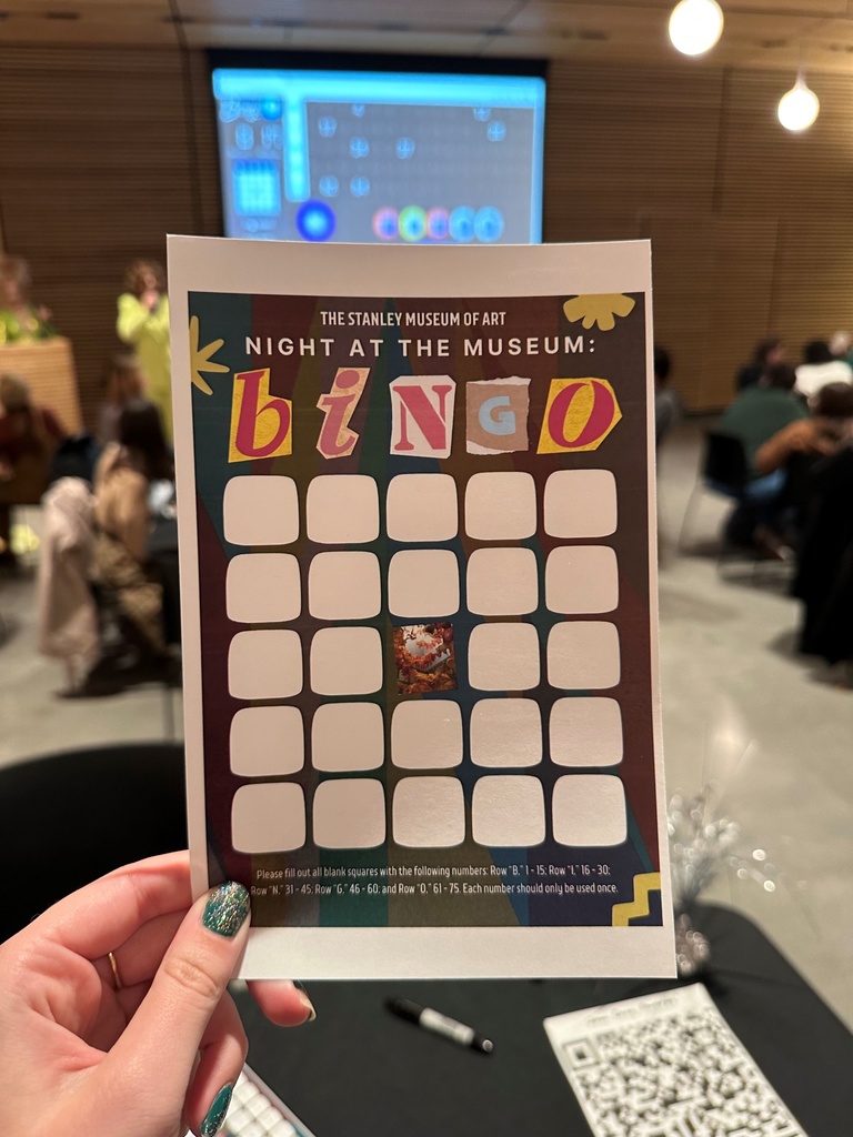 hand holding the bingo card used at the event. the middle tile shows a picture of spirit dance 