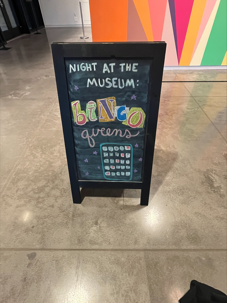 written in colorful chalk is a sign indicating the bingo queen event 