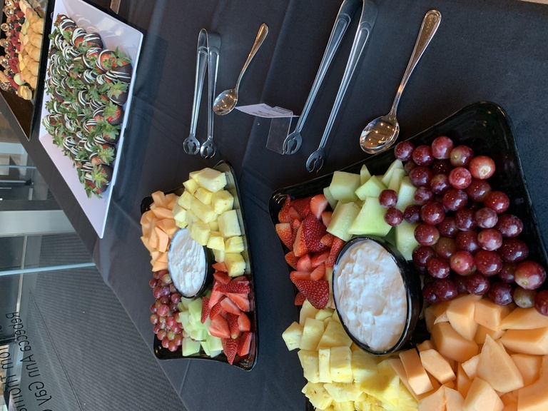 shown is a fruit tray with various types of fruits and a white dip 