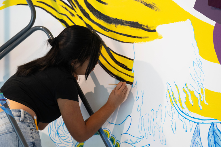 A person painting designs on a wall