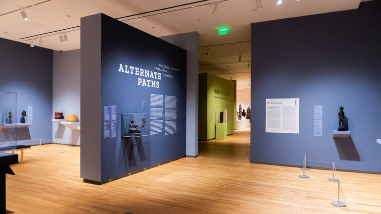 Image of a gallery with purple walls and African art on display