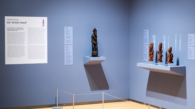 Image of a gallery with purple walls and African art on display