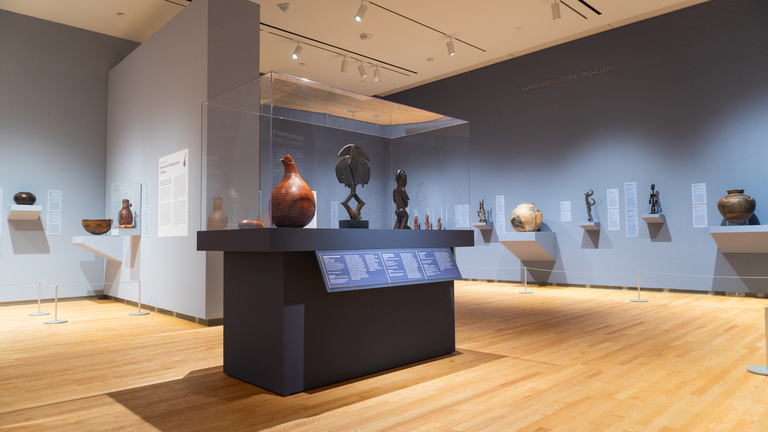 Image of a gallery with purple walls and African art on display