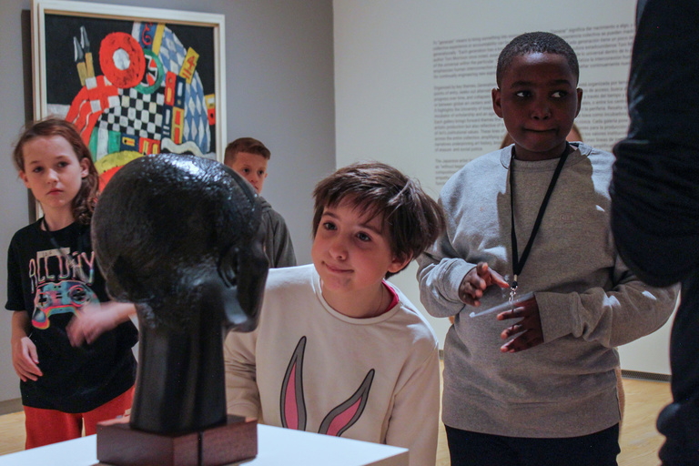 A girl looks at a sculpture in a gallery