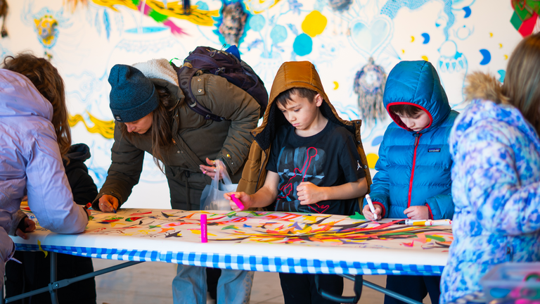 Young children and university students alike work on the MLK murals.