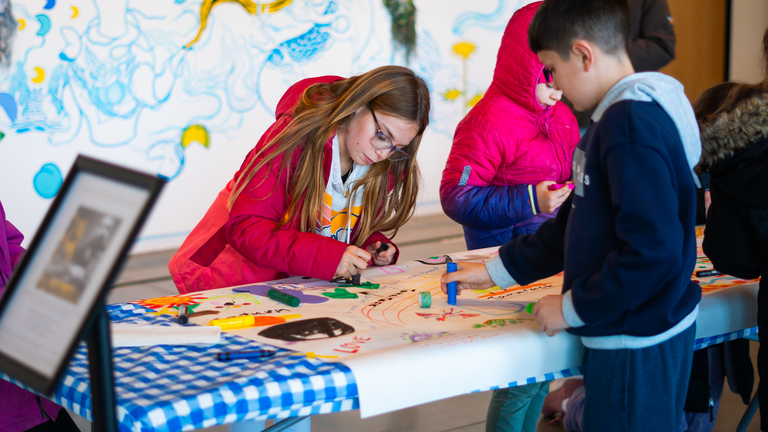 Two children add drawings to the MLK murals.