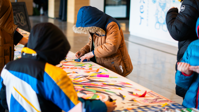 Two children add drawings to the MLK murals.