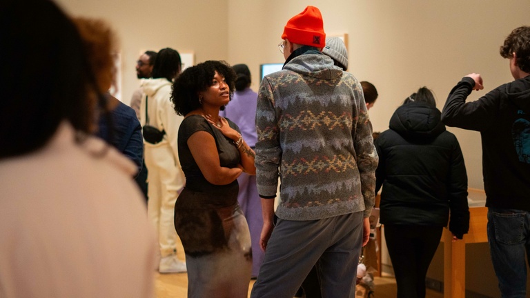 A group of people chatting and socializing in an art museum 