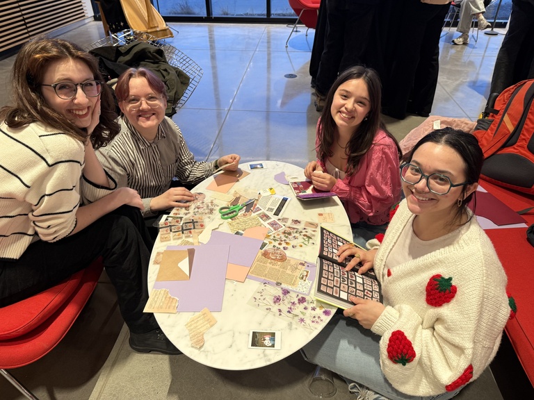 Students sit at the marble tables in the lobby and craft