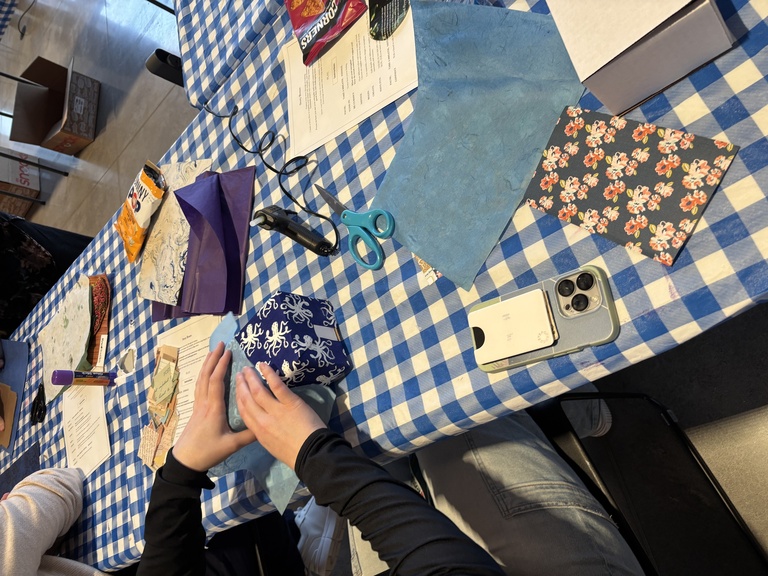 A student folds various papers around their cardboard story box.