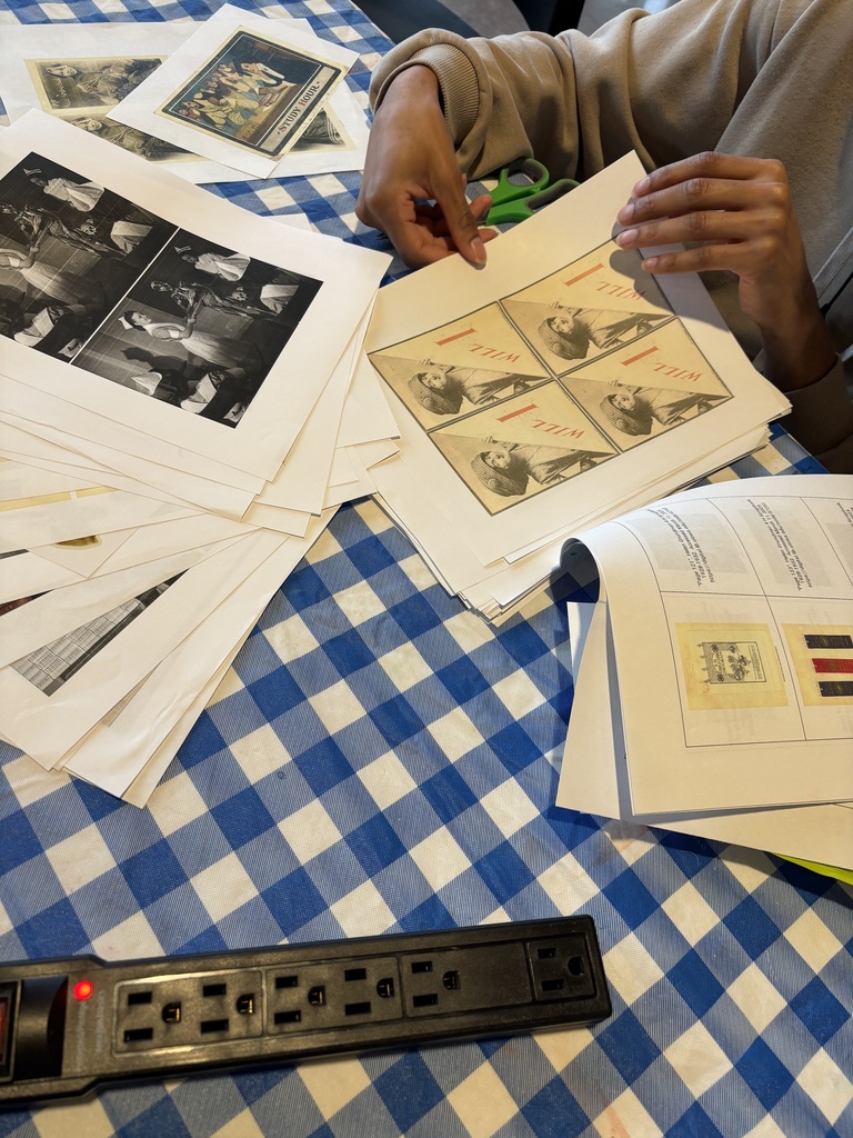 A student flips through printed out collage materials.