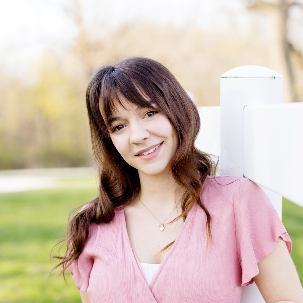 A photo of Annelise Richardson: she is wearing a pink top and smiling at the camera.