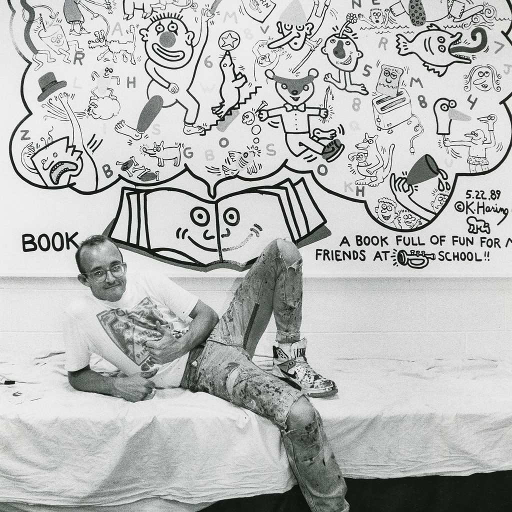 Keith Haring posing with his mural at Horn Elementary School