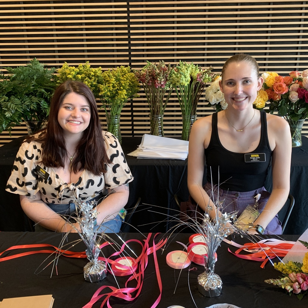 two students working at the flower station. Alexis Belme the campus engagement coordinator is one the left and Georgia Corbin a gallery host is one the right 