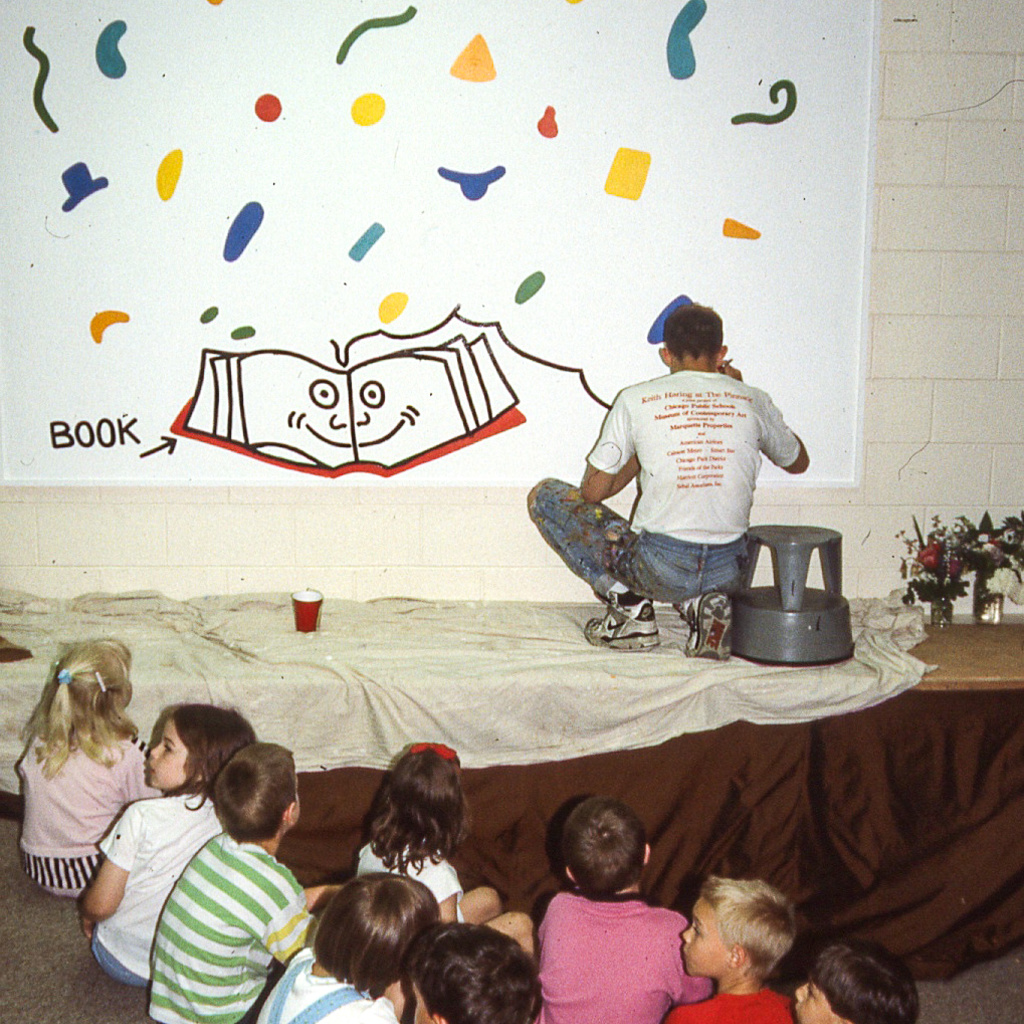 Keith Haring at work on the mural at Ernest Horn Elementary School, 1989. Photographer unknown. Image courtesy of Colleen Ernst. © Keith Haring Foundation.