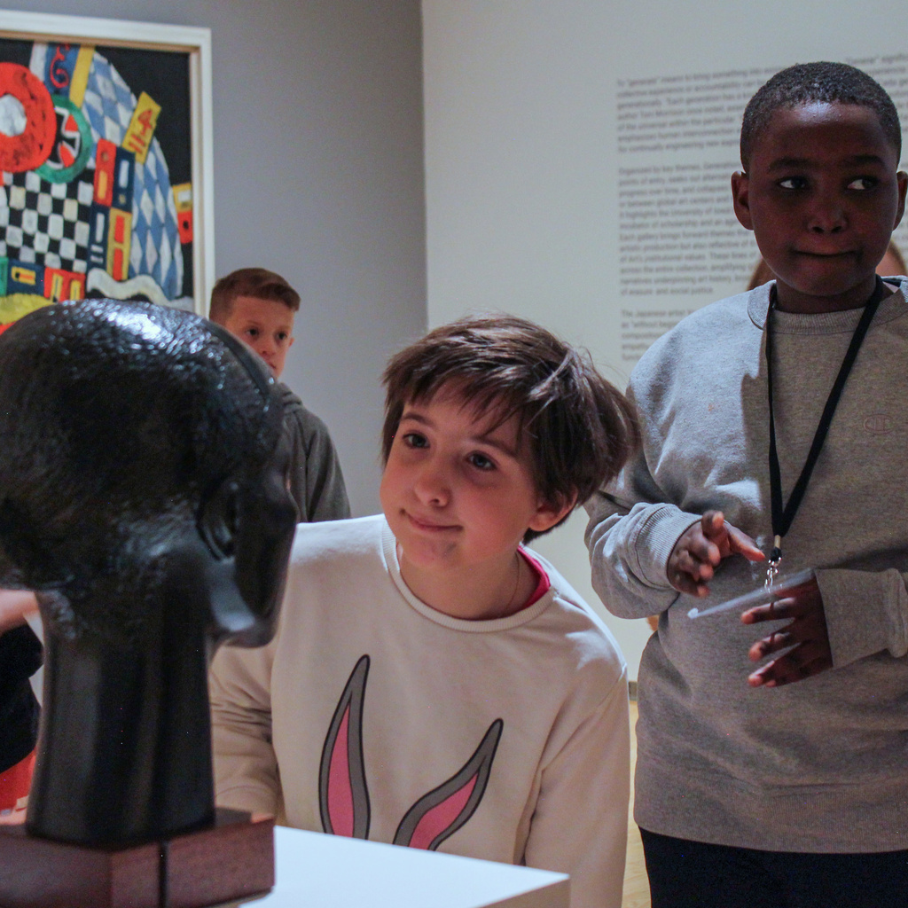 A girl looks at a sculpture in a gallery