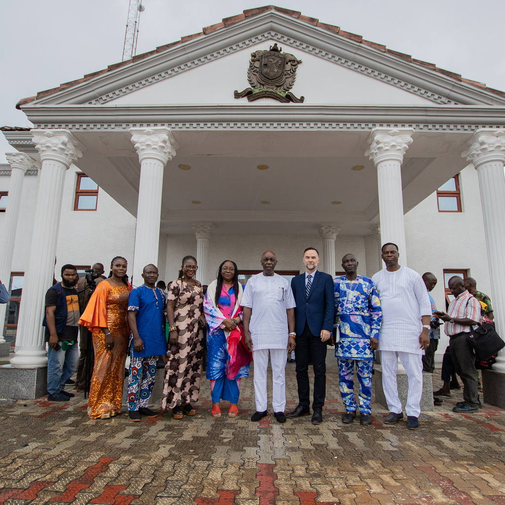 A group of people standing in front of a white palatial building
