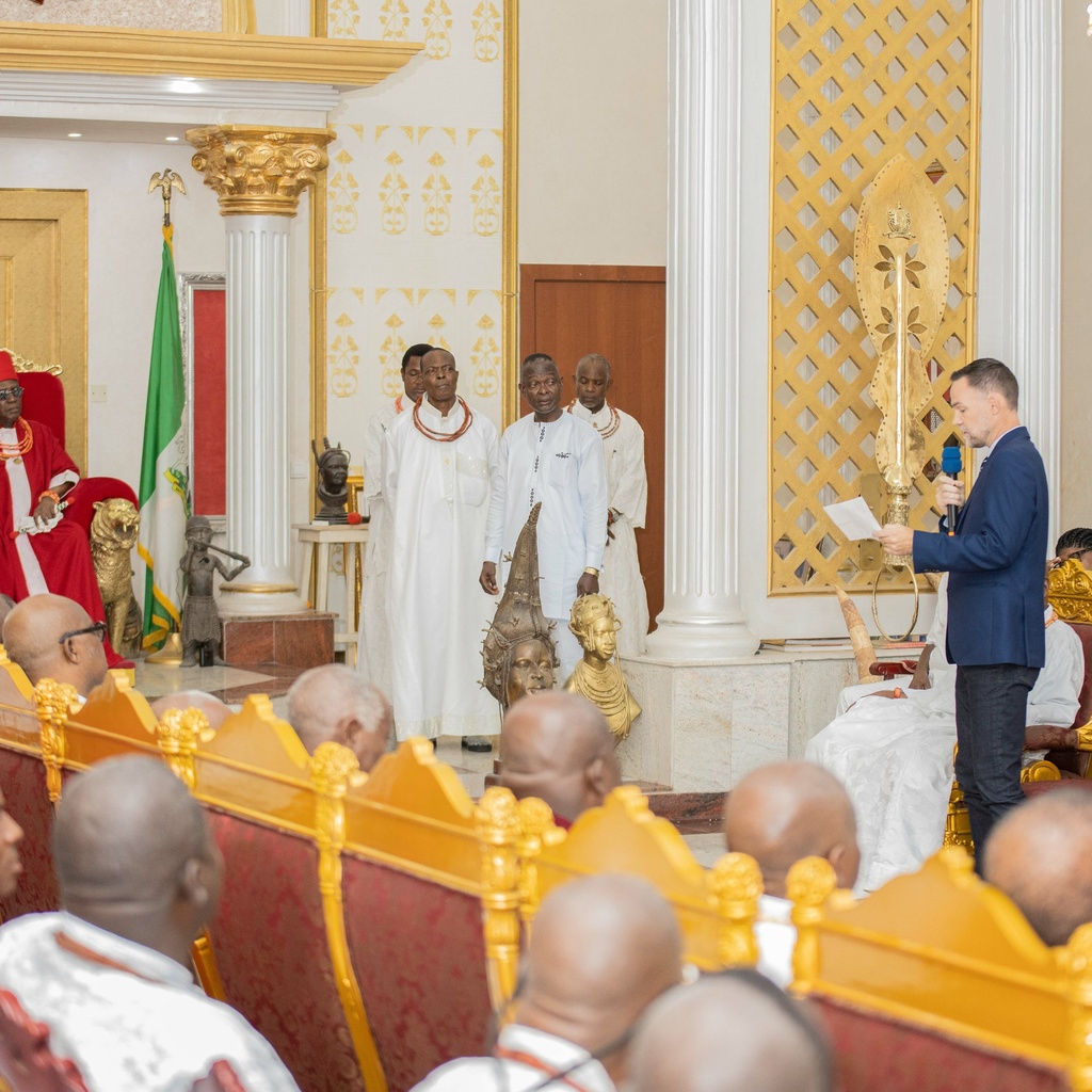 A court full of seated officials looking at a person in a suit speaking into a mic
