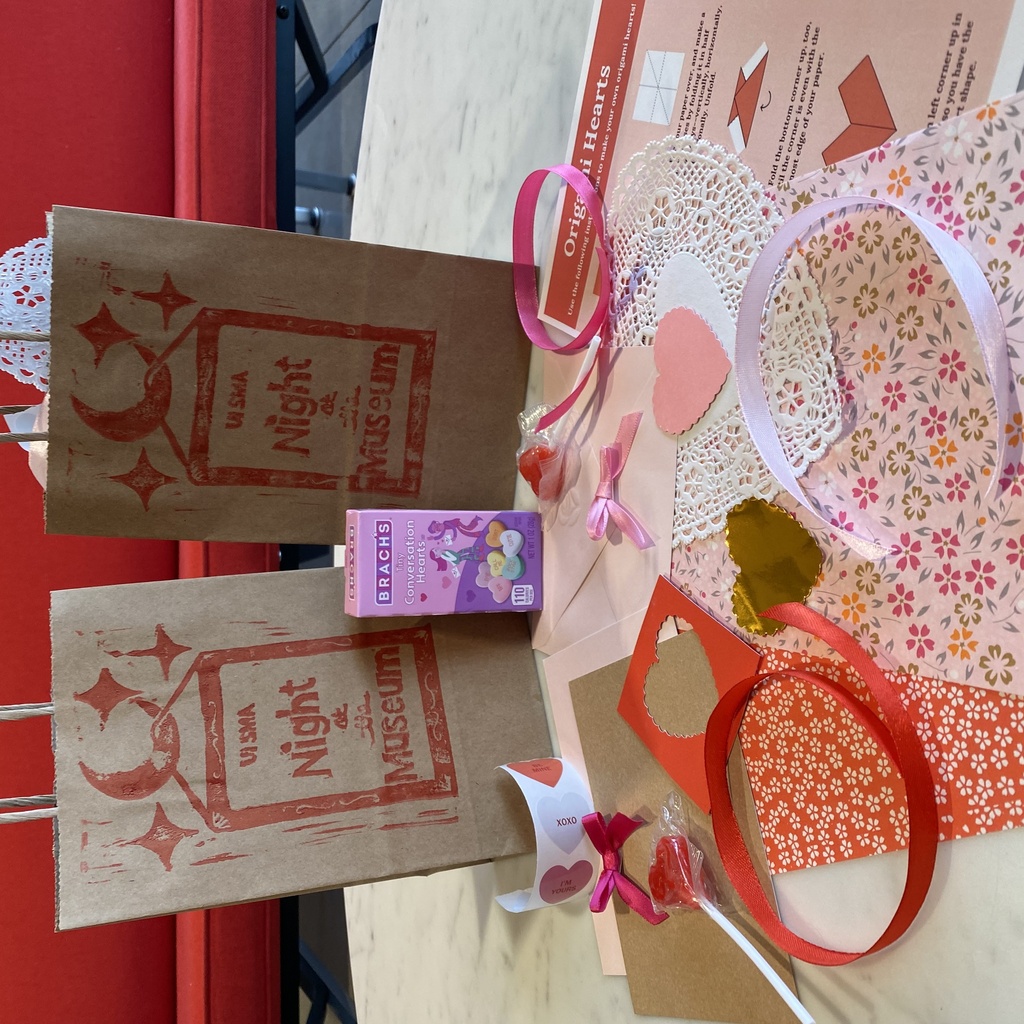 A photo of two valentine's craft bags and their contents: candies, blank valentines, ribbons, stickers, and more.