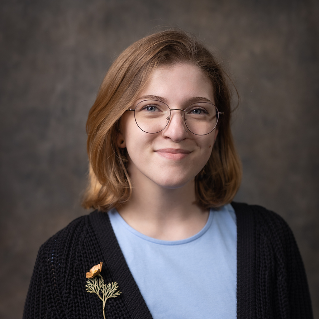 A photo of Katharine with a grey background. 
