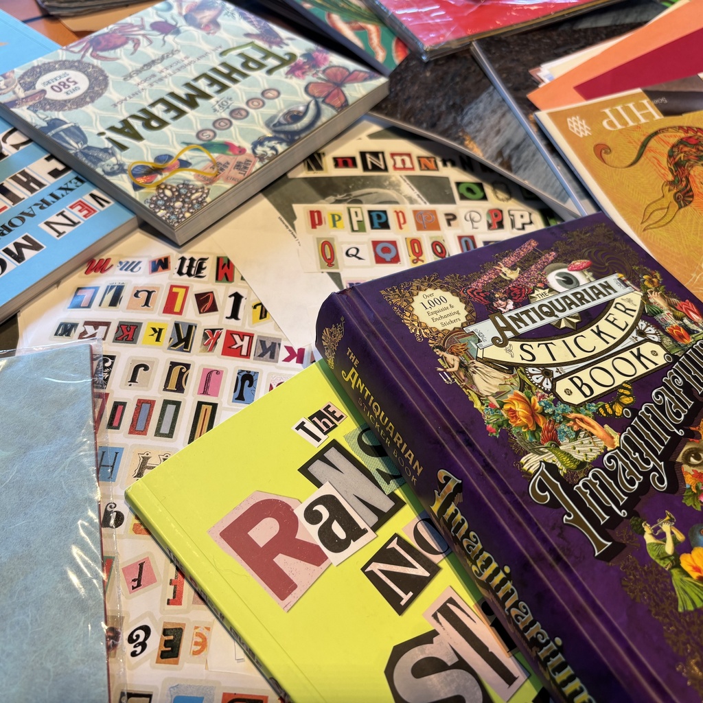 A photo of collage books, stickers, and other materials.