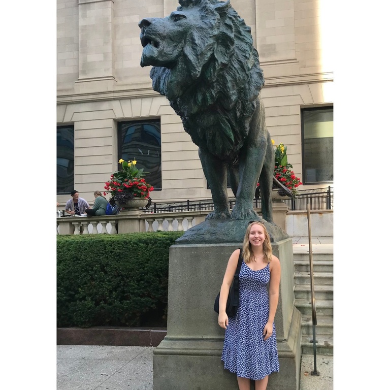 A photo of Josie Duccini in front of a lion statue