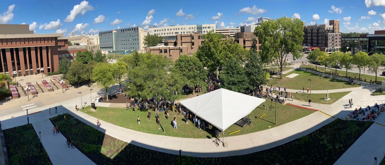 Aerial view of Gibson Square Park with large white tent and big crowd of people