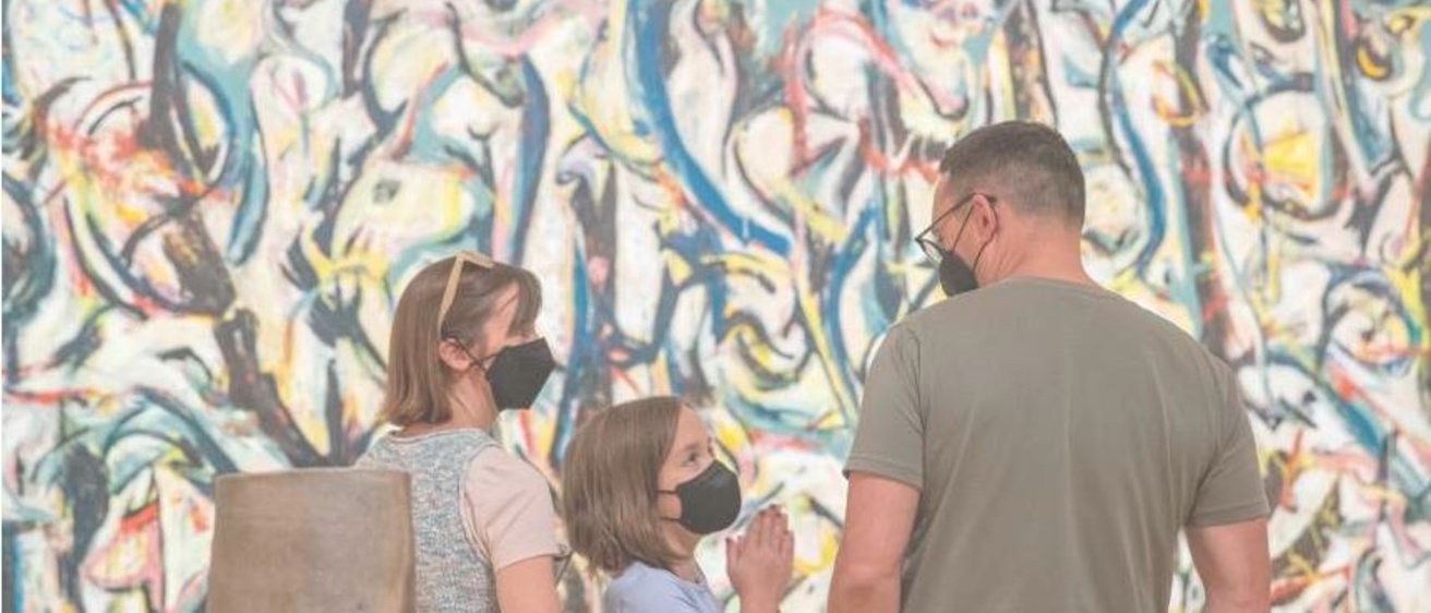 Beatrice Casto, 9, of Iowa City, talks with her parents, Heidi Casto (left) and Andrew Casto while looking at Jackson Pollock’s masterpiece, “Mural,” during the opening weekend event at the Stanley Museum of Art on August 26, 2022. The Castos are art instructors at the University of Iowa art school and wanted to take their daughter to the opening of the museum. Photo by Savannah Blake, The Gazett